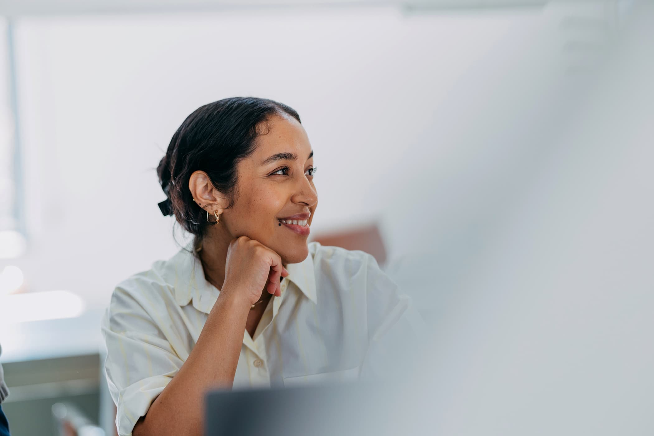 Woman smiling and looking to the right at something out of frame.